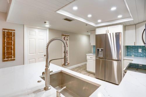 a kitchen with a sink and a refrigerator at 707 Sandcastle One in Clearwater Beach
