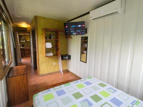 1 dormitorio con 1 cama y TV en la pared en Arenal Homes La Fortuna en Fortuna