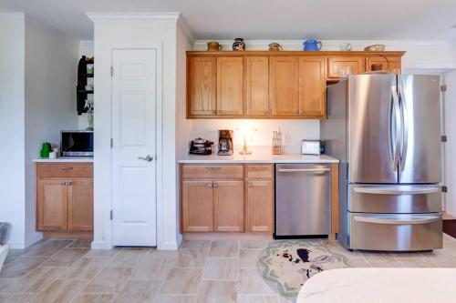 La cuisine est équipée d'armoires en bois et d'un réfrigérateur en acier inoxydable. dans l'établissement Bovina Mountain Meadow, à Bovina Center