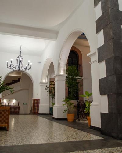 a lobby of a building with a chandelier at Hotel Catedral in Cuernavaca
