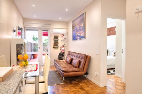 a living room with a leather couch and a table at Refugio in Porto