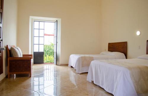 a hotel room with two beds and a window at Hotel Catedral in Cuernavaca
