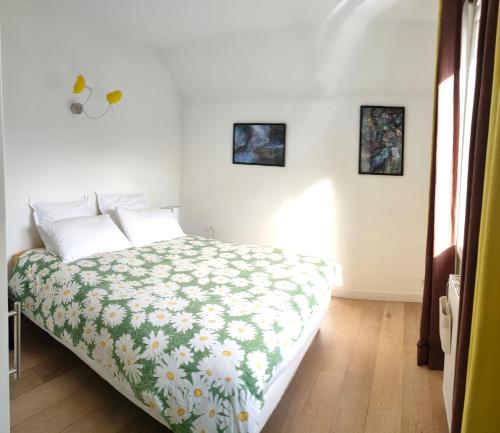 a bedroom with a bed with a green and white blanket at Villa Meyronnes in Barcelonnette