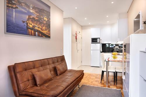 a living room with a couch and a kitchen at Refugio in Porto