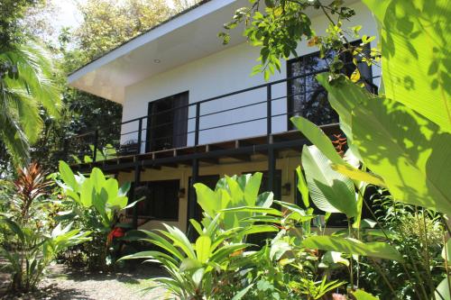a house with a balcony in the middle of a garden at Miah house in Puerto Jiménez