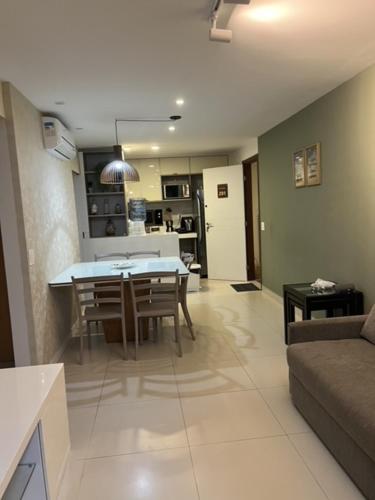 un soggiorno e una cucina con tavolo e sedie di Flat luxo 3 qtos NUI SUPREME - Beira Mar de Muro Alto a Porto De Galinhas