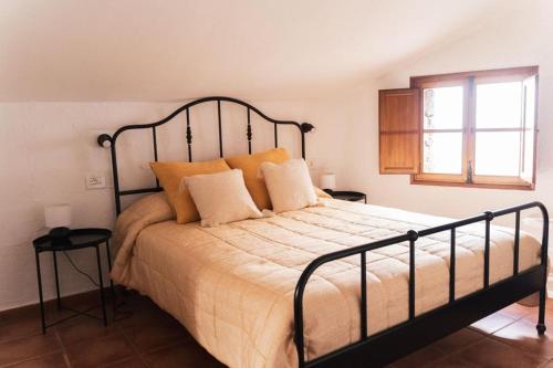1 dormitorio con 1 cama grande con almohadas de color naranja en Vivienda Vacacional Tanganasoga, en La Frontera