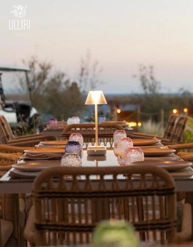 a long table with plates and a lamp on it at Green Coast Resort V94 in Palasë
