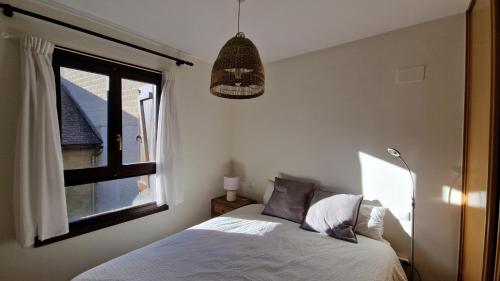 1 dormitorio con cama y ventana en Apartamento centro de Sallent con WIFI, en Sallent de Gállego