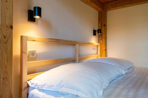a bed with a wooden headboard in a room at Apartmány Pod Kolonádou in Janske Lazne