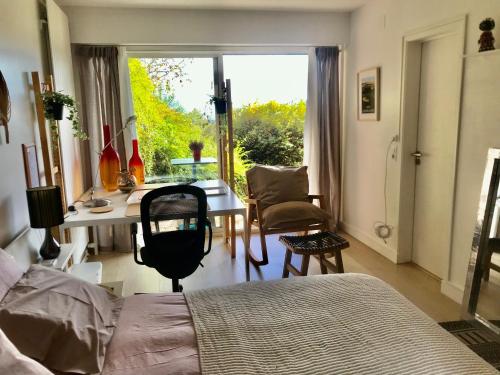 1 dormitorio con cama, escritorio y ventana en Chez Isa, espace prive, 1ou 2 chambres, terrasse et jardin, entrée autonome, sdb et mini cuisine partagées entre les 2 chambres, en Ceyrat