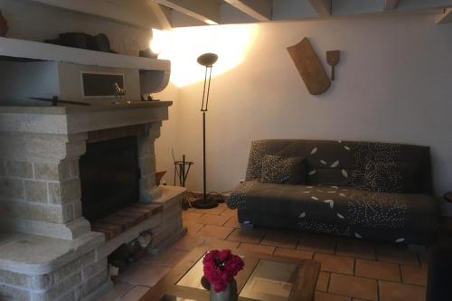 sala de estar con sofá y chimenea en Chambres d'Hotes dans les Gorges de la Sioule en Chouvigny