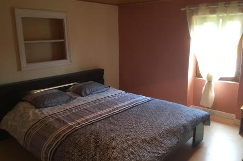 1 dormitorio con 1 cama con 2 almohadas y ventana en Chambres d'Hotes dans les Gorges de la Sioule en Chouvigny