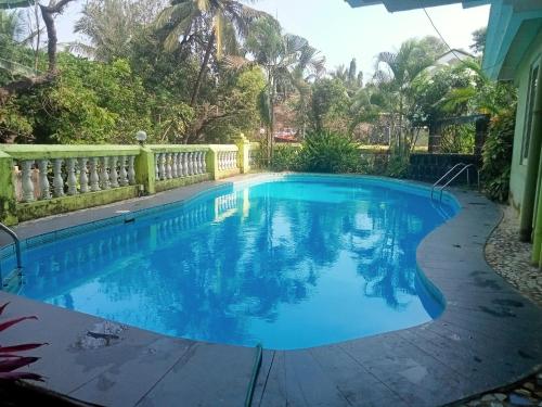 a swimming pool in a backyard with a fence at Asian Paradise comfort in Varca