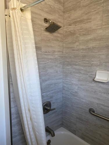 a shower with a tub and a shower curtain at Western Holiday Lodge in Three Rivers