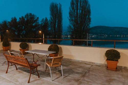 a patio with a table and chairs on a balcony at view kastoria in Kastoria