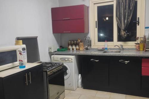 a kitchen with a stove top oven next to a microwave at 2 bed 2 bath,pool facility,roof top with sea view in Sharm El Sheikh