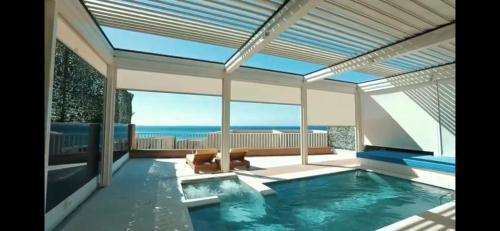 a swimming pool with a view of the ocean at Green Coast Resort V94 in Palasë