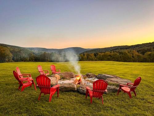 a group of chairs around a fire in a field at Bull Run Ranch in Margaretville