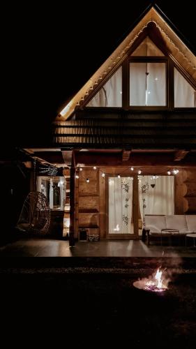 a log cabin with a fire in front of it at Stylowa Chata in Zakopane