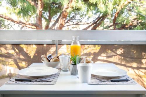 - une table avec des assiettes de nourriture et une bouteille de jus d'orange dans l'établissement Résidence Bord de Mer-Terasse-plage prado David, à Marseille
