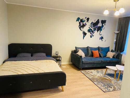 a bedroom with a bed and a couch at 1-bedroom loft in Siena Tirgus in Rīga