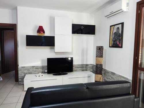a living room with a couch and a tv at Vico Stazione Apartment in Uta