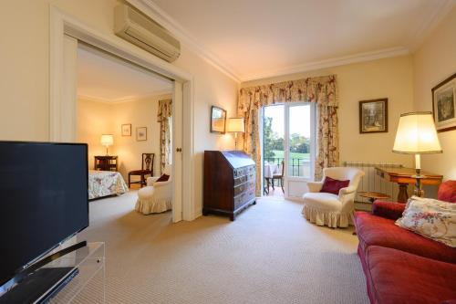 a living room with a television and a bedroom at Villa at Quinta do Perú Golf and Country Club in Quinta do Conde