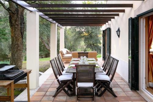 an outdoor dining room with a table and chairs on a patio at Villa at Quinta do Perú Golf and Country Club in Quinta do Conde