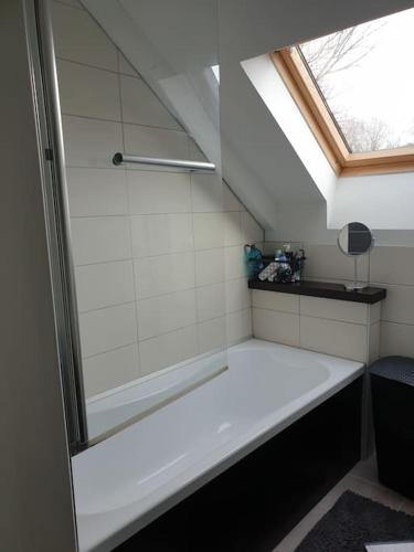 La salle de bains est pourvue d'une baignoire et d'une fenêtre. dans l'établissement Appartement de la laiterie avec petit jardin., à Eysus