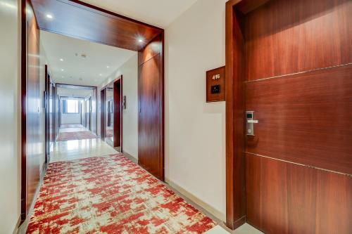 a hallway with a wooden door and a rug at Hotel Gurudev Grand in Kalyan