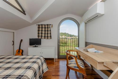 Dormitorio con cama, escritorio y TV en Villa Siveri - private swimming pool - air con, en Figline Valdarno