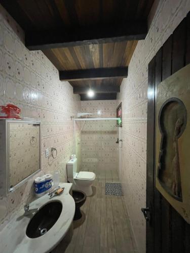 a bathroom with a sink and a toilet at Casa Marrom in Bombinhas