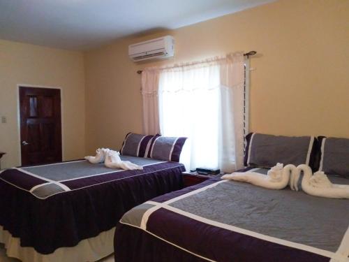 Dos camas en una habitación con toallas. en Valentine's Castle en Saint Annʼs Bay