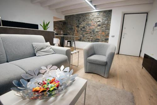 una sala de estar con sofá y un plato de flores en una mesa. en larius apartment, en Como