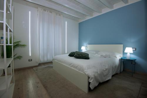 um quarto branco com uma cama e uma janela em larius apartment em Como