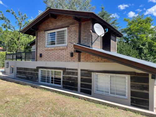 a house with a satellite on the side of it at La Franca Cabaña de Veraneo in Villa General Belgrano