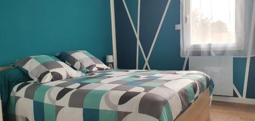 una camera con un letto in una camera blu di Charmant logement neuf a Hourtin