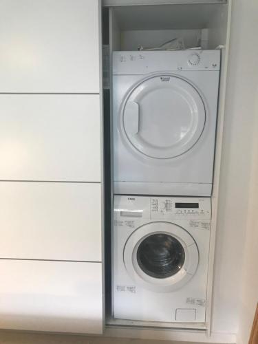 a washer and dryer in a small room at Skøn feriebolig med havudsigt i naturskønt område in Munkebo