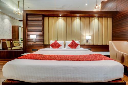 a large bedroom with a large bed with red pillows at Hotel Gurudev Grand in Kalyan