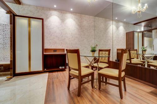a dining room with a glass table and chairs at Hotel Gurudev Grand in Kalyan