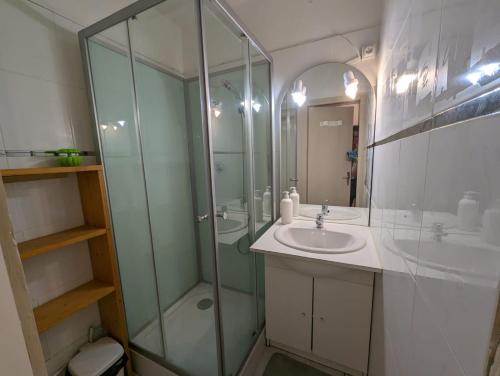 une salle de bain avec une douche en verre et un lavabo dans l'établissement Studio 1 pièces avec balcon pieds des pistes la mongie tourmalet, à Bagnères-de-Bigorre