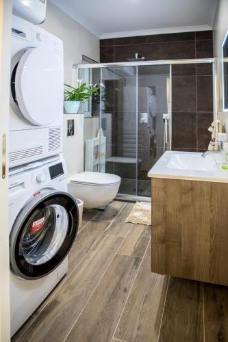 a bathroom with a washing machine and a sink at 2 bedroom luxury design apartment in Żabbar