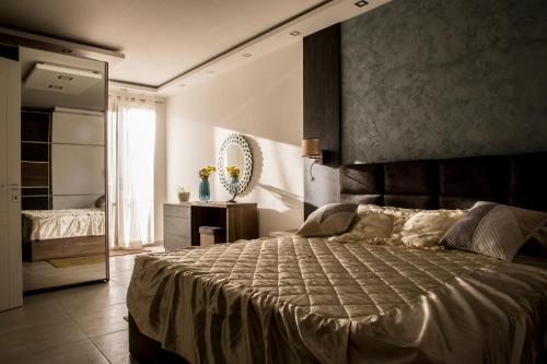 a bedroom with a large bed and a mirror at 2 bedroom luxury design apartment in Żabbar