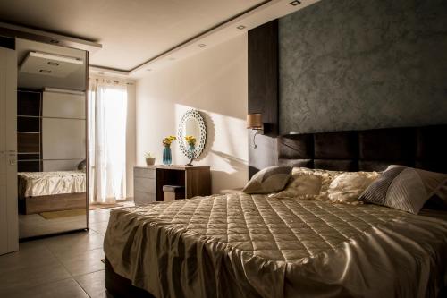 een slaapkamer met een groot bed en een spiegel bij 2 bedroom luxury design apartment in Żabbar