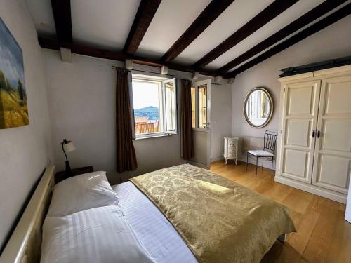 - une chambre avec un lit et une grande fenêtre dans l'établissement Beautifully Restored 400-year Old House with Stunning Sea Views from the Terrace, à Dubrovnik