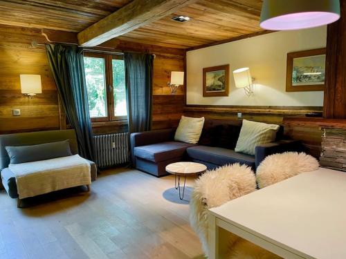 un soggiorno con divano e tavolo di Logement à Megève avec Jardin a Megève
