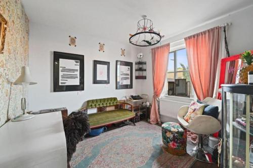 a living room with a green couch and a window at Artist's eclectic Town House close to river in Woodbridge