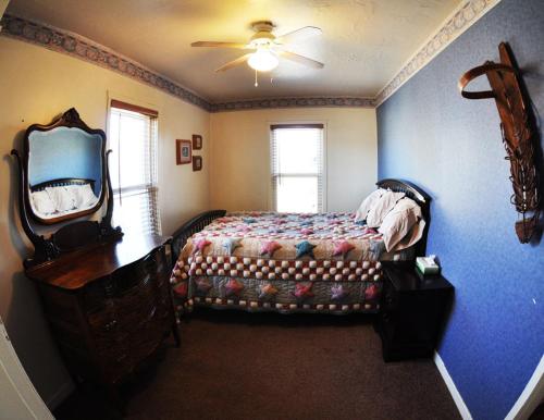 a bedroom with a bed and a dresser and a mirror at Wild West Retreat in Escalante