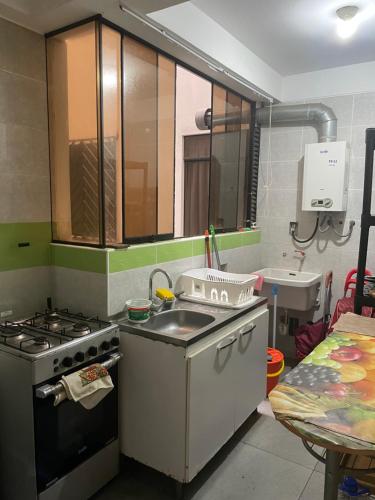 a small kitchen with a sink and a stove at Hermoso departamento en pueblo libre cerca al aeropuerto in Lima